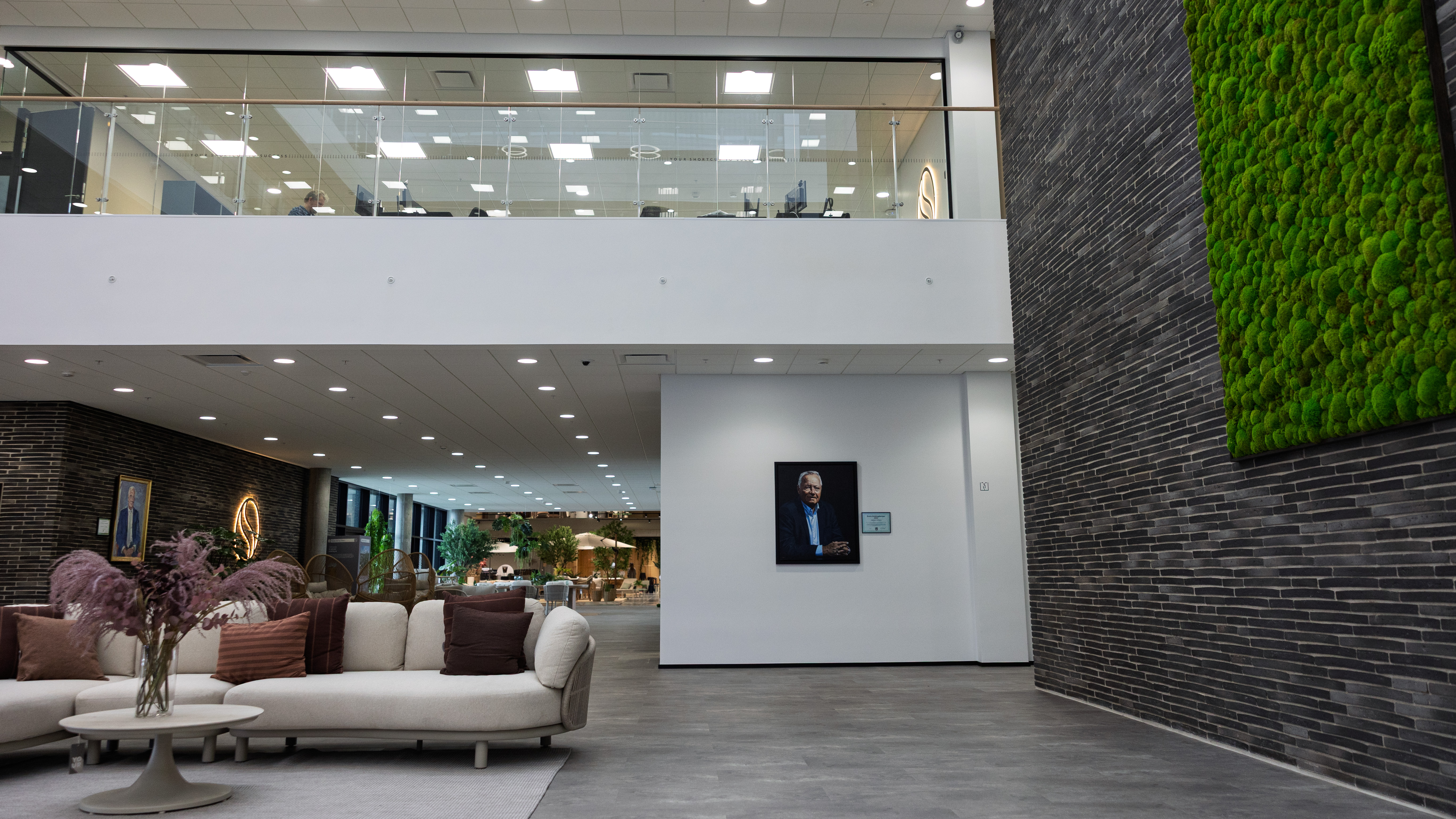 På en af væggene i det store atrium, i midten af grossisten SCHOU's nye hovedkontor, hænger der et maleri af den nuværende ejer Jørgen Schou.
